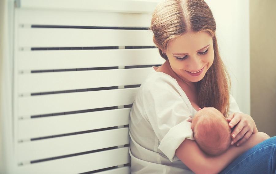 Young mother embracing newborn baby.