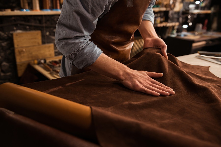 Male cobbler working with leather textile.