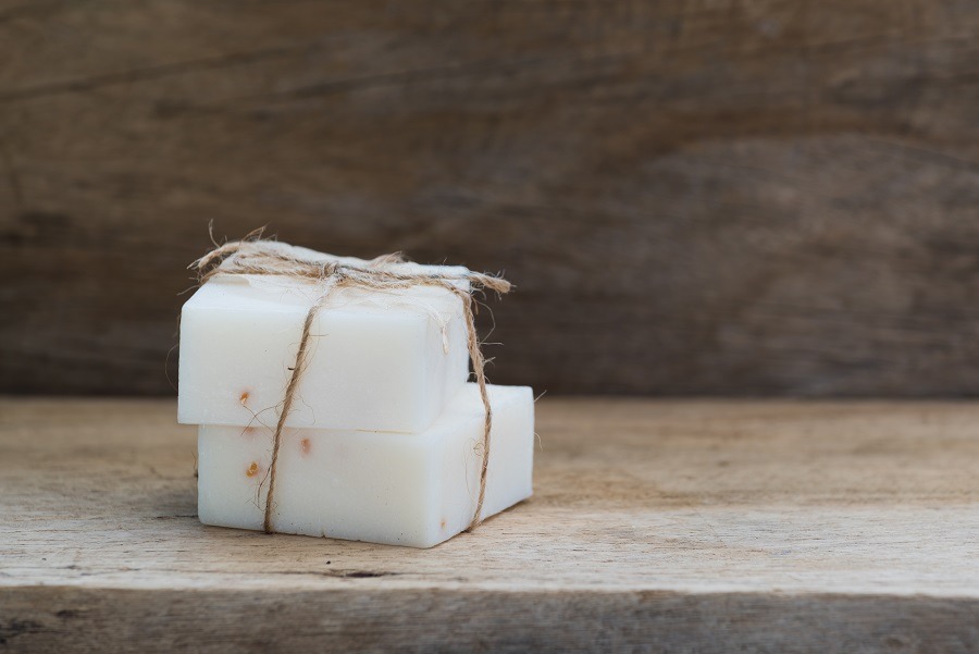 Handmade milk soap on top of wooden table.