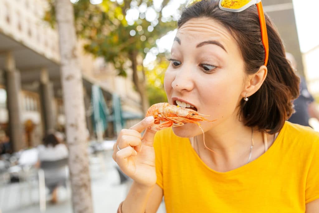 Woman eating delicious seafood shrimp.